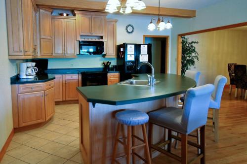 a kitchen with a sink and a counter with stools at Marina Vista in Penn Yan