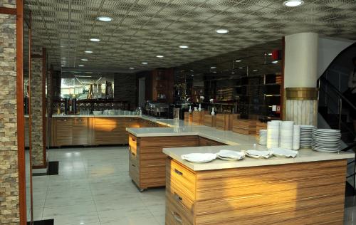 a large kitchen with wooden cabinets and a counter at Lion City Hotel Ankara in Ankara