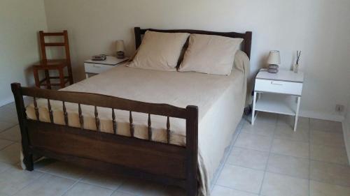 - une chambre avec un lit, deux tables et une chaise dans l'établissement Maison dans Quartier Calme, à Lacanau-Océan