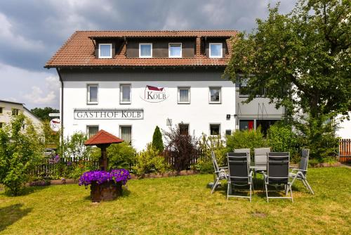 un grupo de sillas sentadas en el césped frente a un edificio en Gasthof Kolb, en Bayreuth