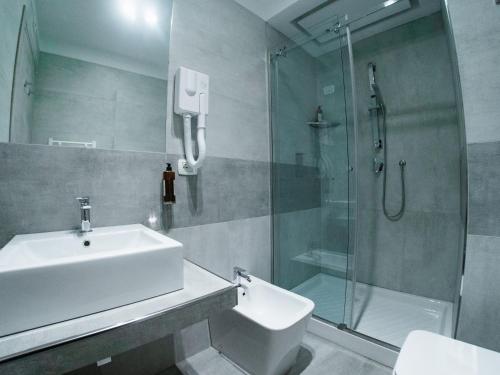a bathroom with a sink and a glass shower at Prestige Rooms Chiaia in Naples