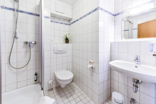 a bathroom with a shower toilet and a sink at Gasthof Kolb in Bayreuth