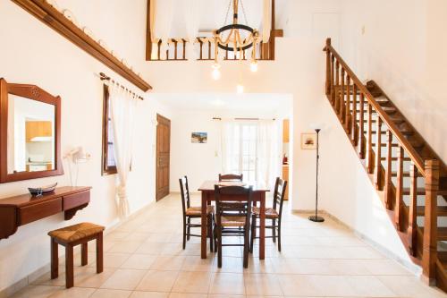 a dining room with a table and chairs and a staircase at Jhonathan in Amoopi