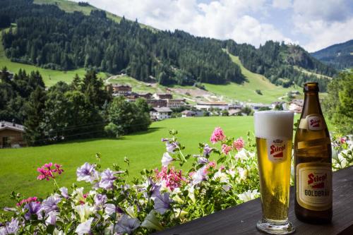 a bottle of beer sitting on a table with a view of a field at Ferienpension Bierbaumer in Leogang