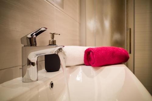 a bathroom sink with a faucet and a red towel at Ferienpension Bierbaumer in Leogang