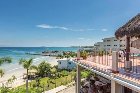 a view of the beach from the balcony of a resort at Hotel La Quinta del Sol in Punta Mita