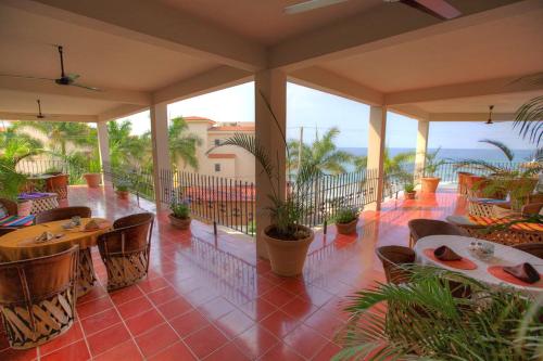 a patio with tables and chairs and the ocean at Hotel La Quinta del Sol in Punta Mita