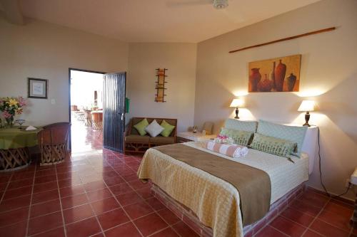- une chambre avec un grand lit et un salon dans l'établissement Hotel La Quinta del Sol, à Punta Mita