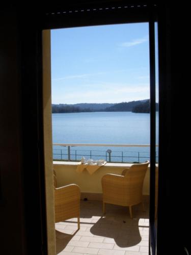 a balcony with a tub and a view of the water at Hotel Miralago in Piediluco
