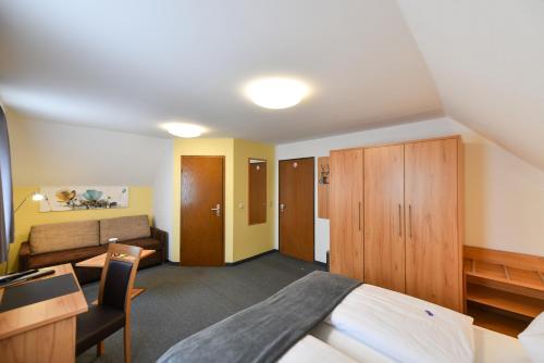 a bedroom with a bed and a couch at Gasthof Kolb in Bayreuth
