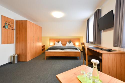 a hotel room with a bed and a desk and a desk at Gasthof Kolb in Bayreuth