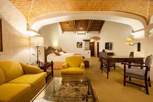 a living room with a room with a bed and a table at Hotel Museo Spa Casa Santo Domingo in Antigua Guatemala