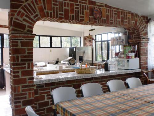 a kitchen with a brick wall and a table and chairs at Hotel Casa de la Luna in San Juan Teotihuacán