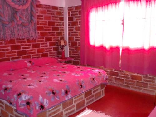 a bedroom with a red bed and red curtains at Hotel Casa de la Luna in San Juan Teotihuacán