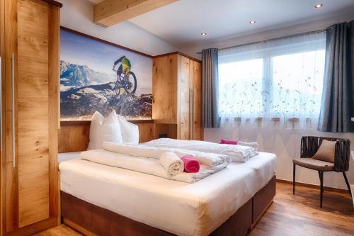 a bedroom with a bed with towels on it at Ferienpension Bierbaumer in Leogang