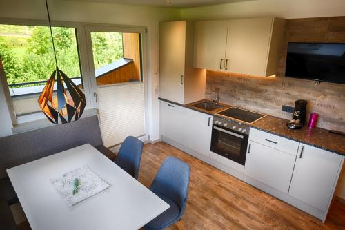 a kitchen with white cabinets and a table and chairs at Ferienpension Bierbaumer in Leogang