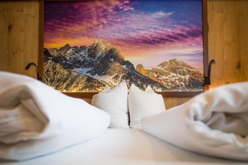 a bedroom with a bed with a picture of a mountain at Ferienpension Bierbaumer in Leogang