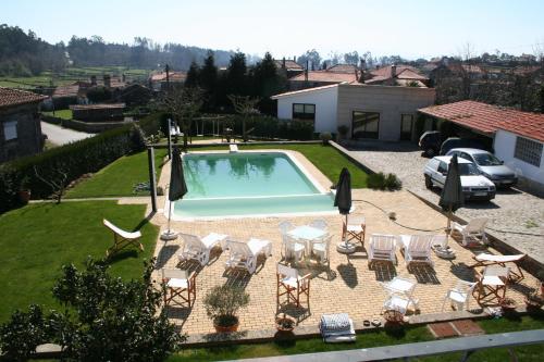una piscina con un gruppo di sedie e un tavolo di Casa Paz do Outeiro a Paredes de Coura