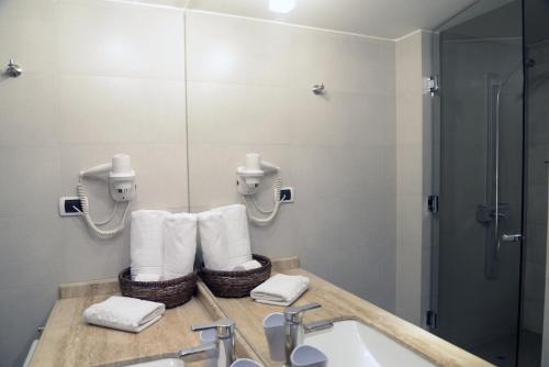 a bathroom with a sink and a shower and towels at Hotel Stanford in Santiago