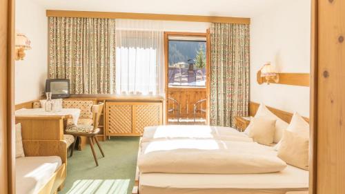 ザンクト・アントン・アム・アールベルクにあるBellamonteのベッド2台とデスクが備わるホテルルームです。