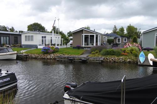 a group of houses on a river with a boat at Watervriend in Earnewâld