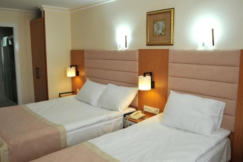 a hotel room with two beds and a phone at Lion City Hotel Ankara in Ankara