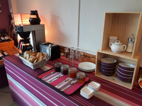 a table with plates and utensils on top at L'Horizon des Landes in Doazit