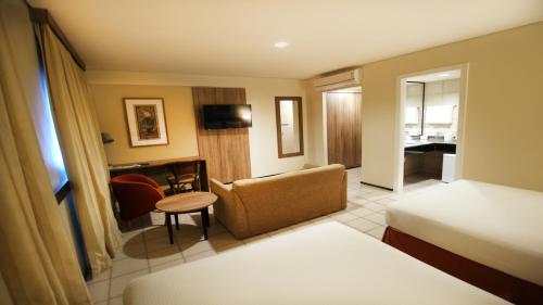 a hotel room with a bed and a chair at Holiday Inn Fortaleza by IHG in Fortaleza