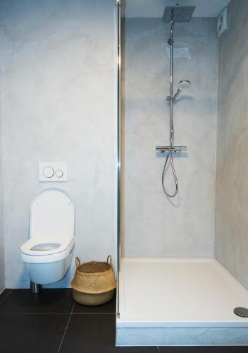 a bathroom with a toilet and a glass shower at B & B Meet the Dutch in Ridderkerk