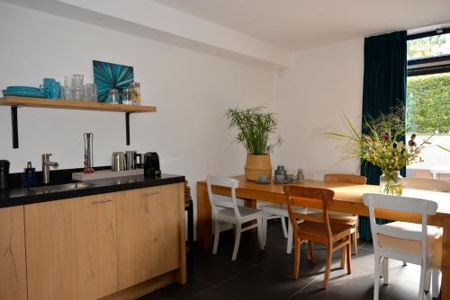 cocina y comedor con mesa de madera y sillas en B & B Meet the Dutch en Ridderkerk