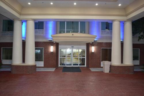 a building with columns in front of a building with blue lights at Holiday Inn Express Hotel & Suites Gainesville by IHG in Gainesville