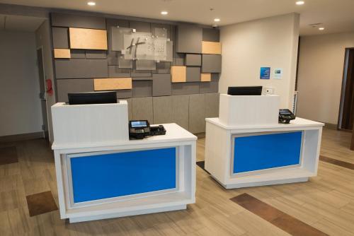 two white tables in a room with blue screens at Holiday Inn Express & Suites - Warsaw - E Center by IHG in Warsaw