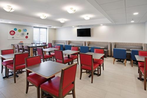 a dining room with tables and chairs and a flat screen tv at Holiday Inn Express Exton - Great Valley by IHG in Exton