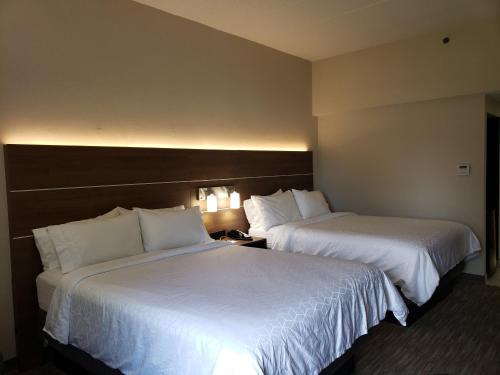 two beds in a hotel room with white sheets at Holiday Inn Express Edgewood-Aberdeen-Bel Air in Edgewood