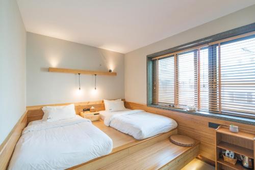 a bedroom with two beds and a window at Zen Tea House Seven Stars Park in Guilin