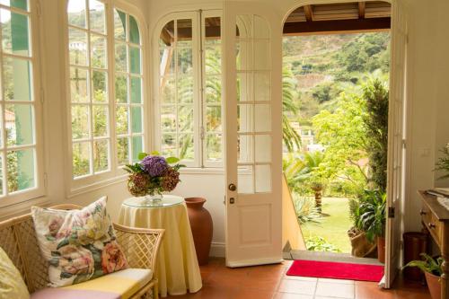 um quarto com uma porta e uma mesa com um vaso em Casa Da Piedade em São Vicente