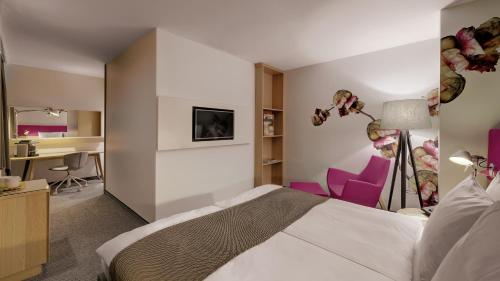 a hotel room with a bed and a desk at Holiday Inn Frankfurt - Alte Oper by IHG in Frankfurt/Main