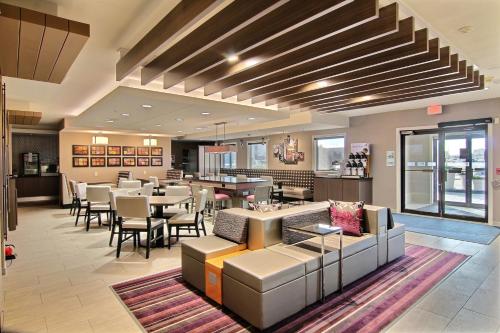 a restaurant with couches and tables and chairs at Holiday Inn Express Fargo - West Acres, an IHG Hotel in Fargo