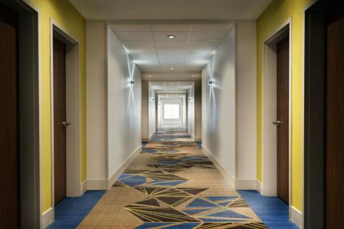 a corridor of a hotel with a carpeted hallway at Holiday Inn Express & Suites - Warsaw - E Center by IHG in Warsaw