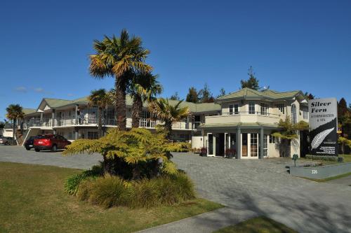 a building with a palm tree in front of it at Silver Fern Rotorua Suites & Spa in Rotorua