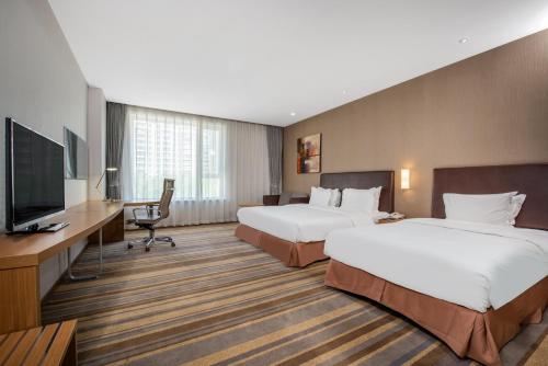 a hotel room with two beds and a flat screen tv at Holiday Inn Express Ordos Dongsheng by IHG in Ordos