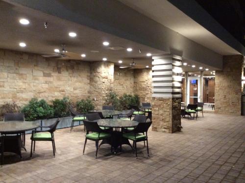 a restaurant with tables and chairs and a stone wall at Holiday Inn Trophy Club by IHG in Trophy Club