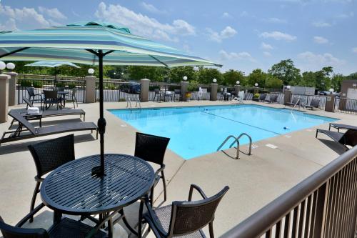 a swimming pool with tables and chairs and an umbrella at Holiday Inn Express Danville by IHG in Danville