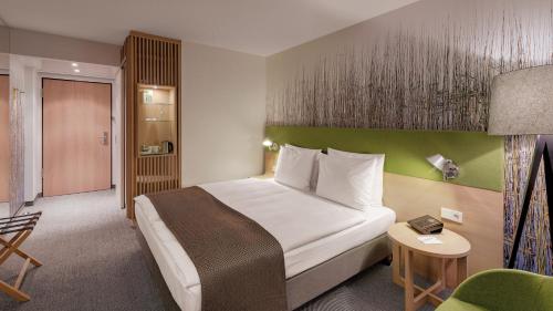 a hotel room with a bed and a chair at Holiday Inn Frankfurt - Alte Oper by IHG in Frankfurt/Main