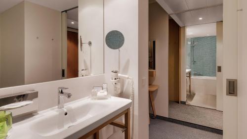a bathroom with a sink and a mirror at Holiday Inn Frankfurt - Alte Oper by IHG in Frankfurt/Main