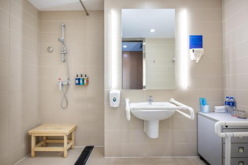 a bathroom with a sink and a shower at Holiday Inn Express Ordos Dongsheng by IHG in Ordos
