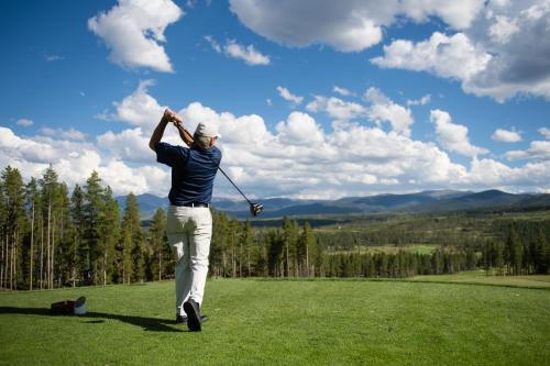a man swinging a golf club on a field at Holiday Inn Express Hotel & Suites Fraser Winter Park Area by IHG in Fraser