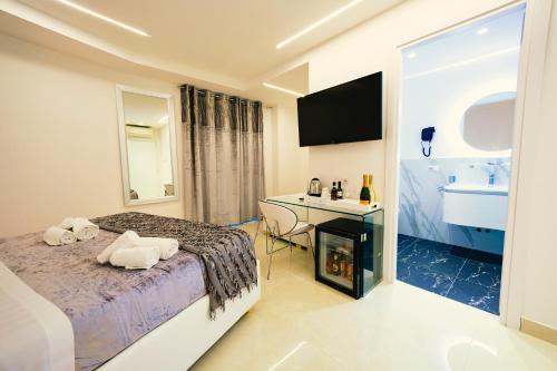 a bedroom with a bed and a desk and a sink at San Pietro Grand Suite in Rome