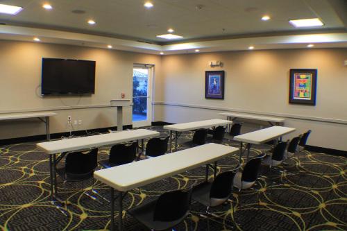 a classroom with tables and chairs and a flat screen tv at Holiday Inn Express & Suites Gonzales by IHG in Gonzales