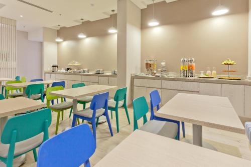 a dining room with tables and blue chairs at Holiday Inn Express Yopal by IHG in Yopal